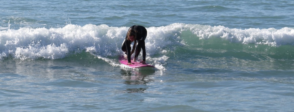 girl standing up on the pink surfboard
