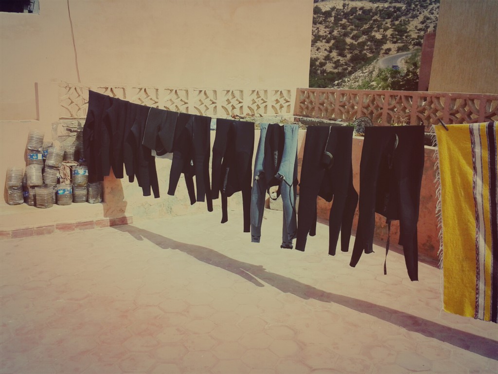 washed wetsuits drying in the sun