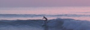 Person surfing sunset in the ocean in Portugal