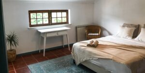 View of the double room with white walls and boho style